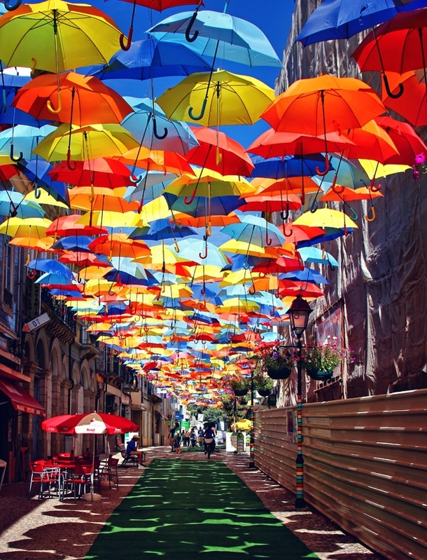 A roof of umbrellas over a courtyard in gueda Portugal Photorator