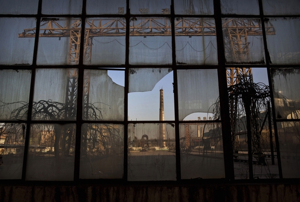A smokestack is seen through a broken window of a building in the abandoned Qingquan Steel plant  one of several so-called zombie factories in Tangshan China Kevin Frayer 