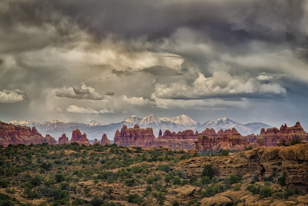 A storm brews over the Needles district of Canyonlands NP with the La Sal Mountains in the distance  photo by Mark Betts