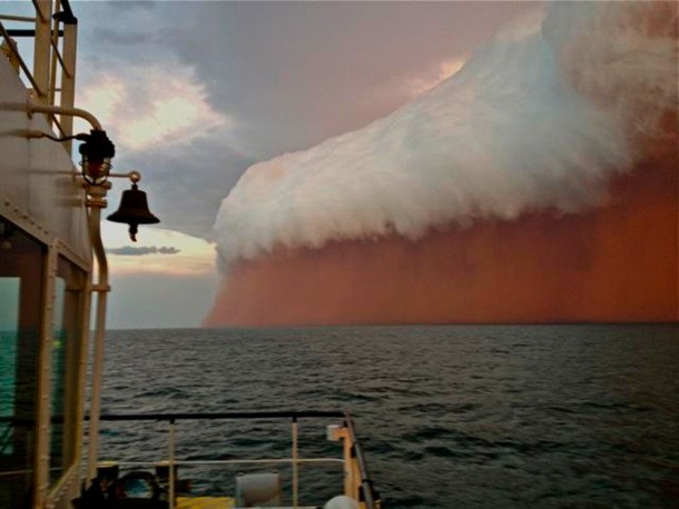 A storm formation tinged with red dust travels across the Indian Ocean near Onslow on the Western Australia coast on January    