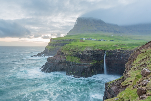 A storm rolling in over Mulafossur Falls in the Faroe Islands 