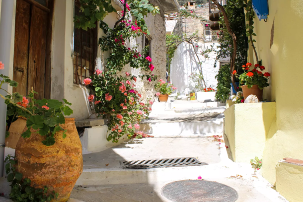 A sun-drenched street with flower pots in Krisa Village - on Crete Island Greece