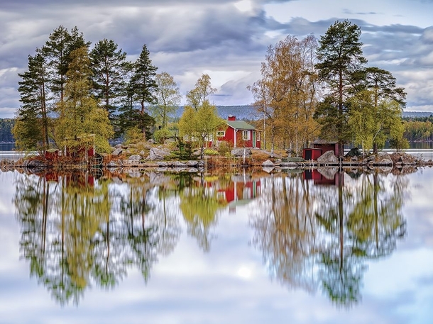 A tiny island reflected in a lake near Sderhamn Sweden  Photo by Torsten Muehlbacher