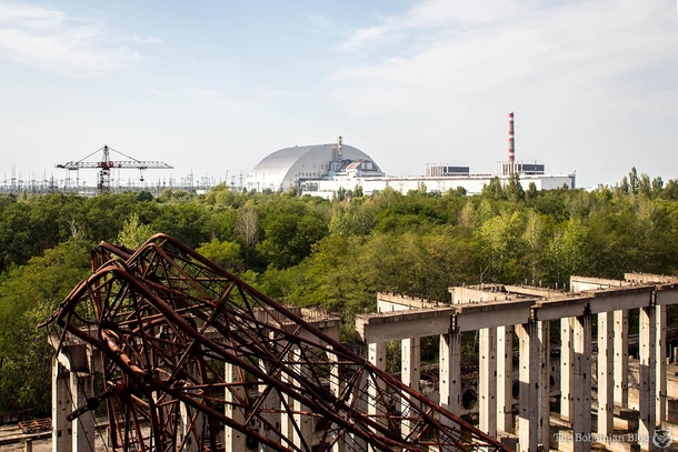 A view of the Chernobyl Nuclear Power Plant From the right Reactors  and  are located beneath the black cubes on the roof of the building  the destroyed Reactor Block  on the left is now covered by the New Safe Confinement Taken from the rooftop of the un