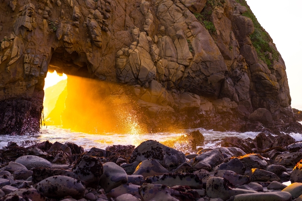A winter portal the sunset light through the keyhole in the rock at Pfeiffer Beach Big Sur California 