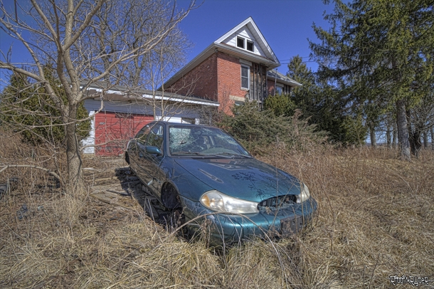 Abandoned Car Sits Out Front of an Abandoned House in Rural Ontario 