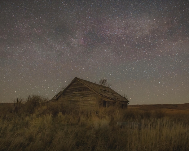 Abandoned farmhouse under a starry sky
