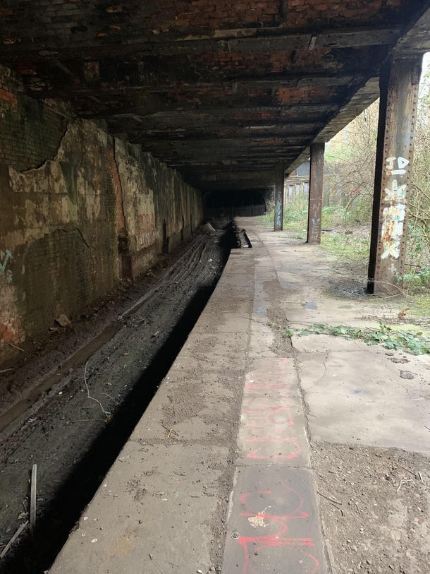 Abandoned railway line and platform with a fenced off tunnel near Glasgow City Centre