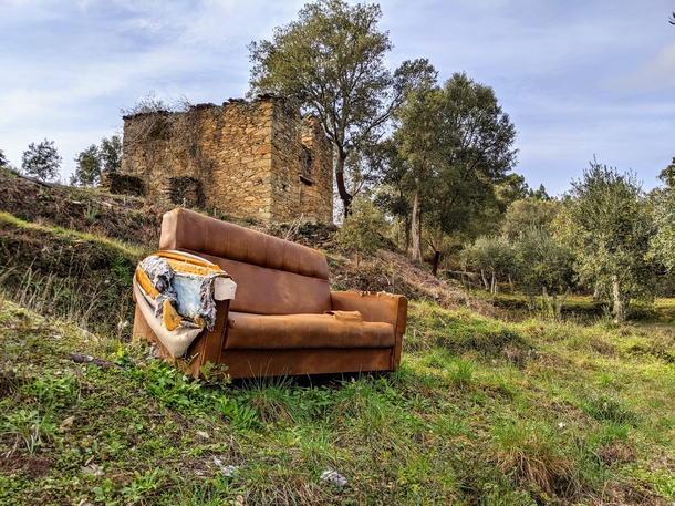 Abandoned sofa near abandoned old house
