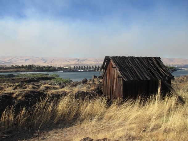 Aging wooden shack near The Dalles dam Oregon backed by the haze of a nearby wildfire 