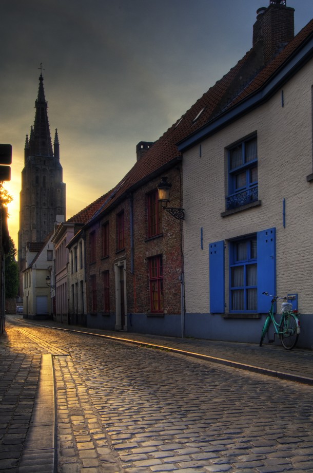An old street in Bruges Belgium with the Church of Our Lady tower in the background 