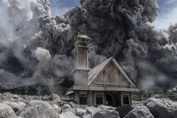 Ash cloud from Mount Sinaburg looms over an abandoned church 