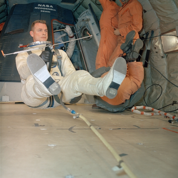 Astronaut David R Scott holds maneuvering unit while suspended in a weightless state during extravehicular activity training  