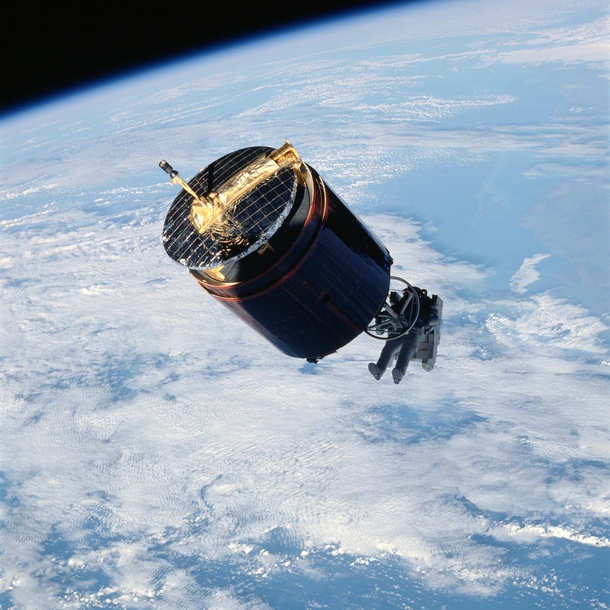 Astronaut wearing the manned maneuvering unit retrieves the Westar VI satellite in 