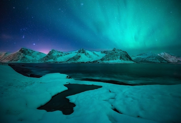 Aurora over a remote mountain range in Senja Norway 