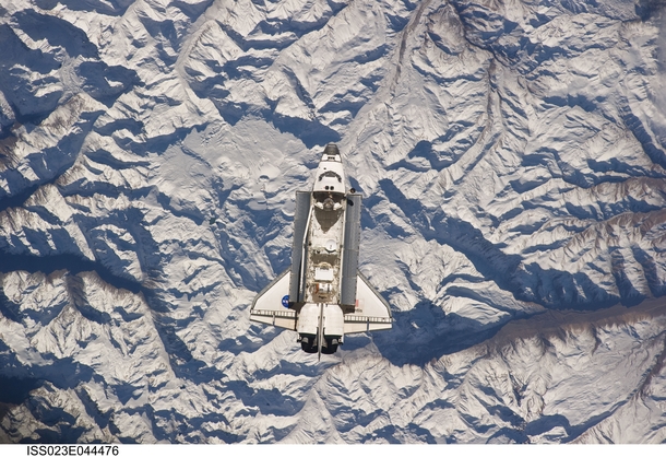Backdropped against the Andes Mountains near the border of Argentina and Chile the space shuttle Atlantis is shown making its relative approach to the International Space Station from which this photo was taken 
