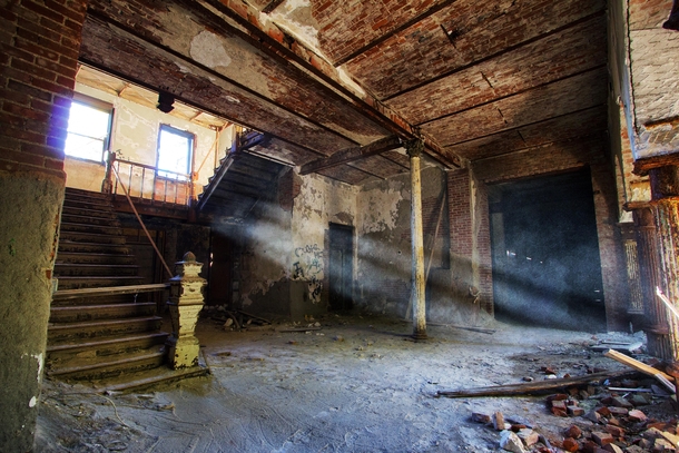 Beams of sunlight illuminate the decaying foyer of the Castle on the Hillside sanatorium