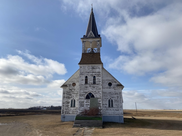 Boarded up church along a North Dakota rural highway The church bell is still in the tower