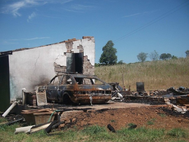 Burned car and house near Porto Vera Cruz Brazil 