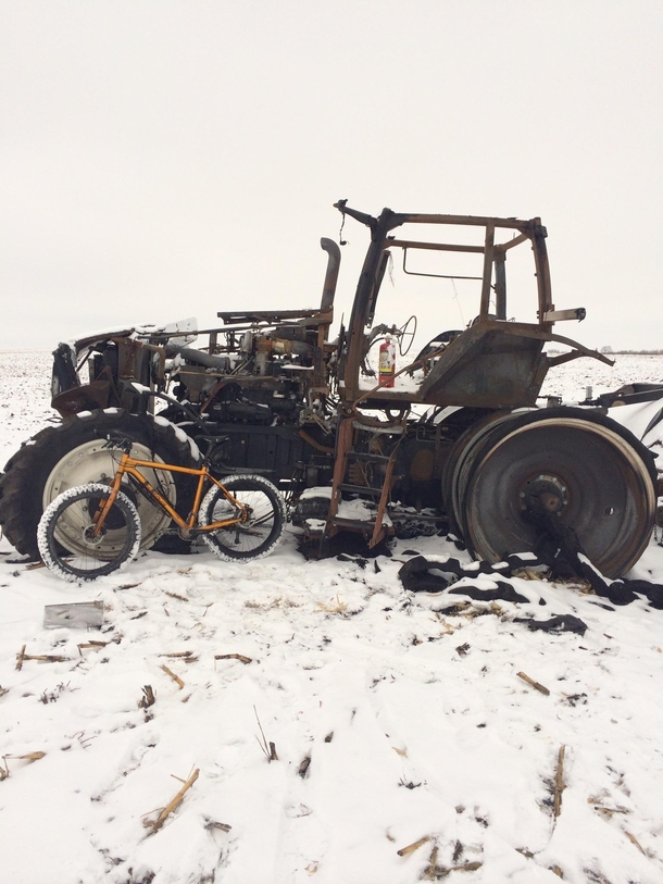 Burnt up tractor in an Iowa field