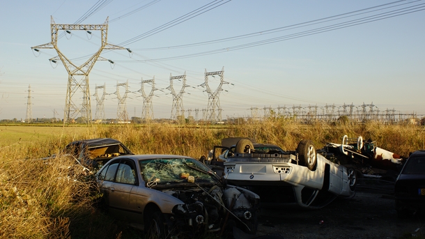 Car cemetery on an electric poles field 