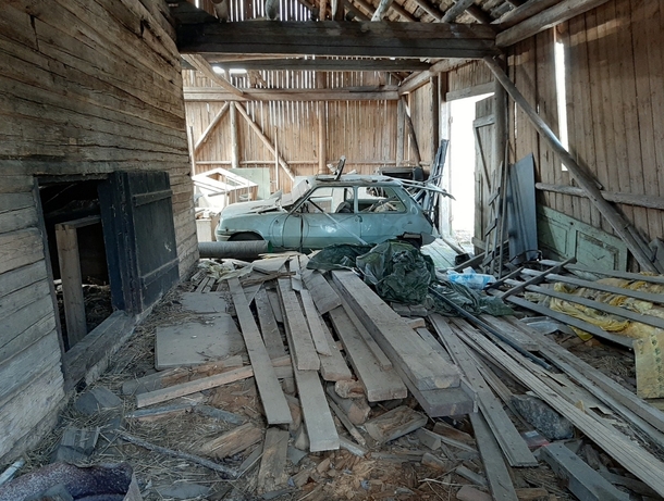 Car in an abandoned barn in finland