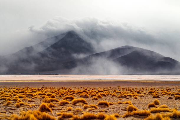 Clouds rolling over mountains on the other side of the Laguna Colorada Bolivia 