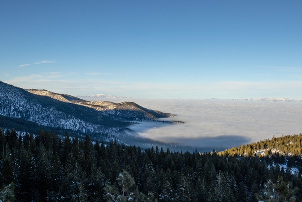 Clouds sit in the bowl of mountains on the other side of Lake Tahoe 