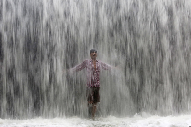 Cooling off under an overflowing dam along Powai Lake 