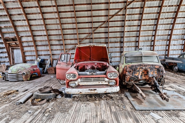 Couple of old trucks in various stages of restoration inside an abandoned barn in Southern Ontario