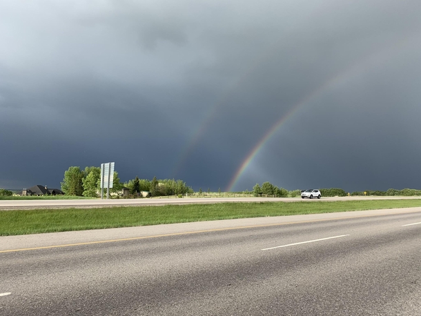 Dark skies with a double rainbow in Alberta