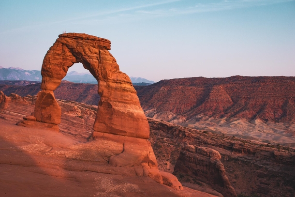Delicate Arch lit up by the waning golden glow of the sun 