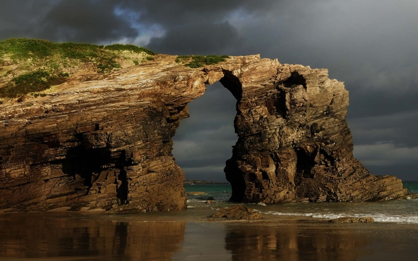 Early morning rain clouds over Las Catedrales beach in Ribadeo Spain 