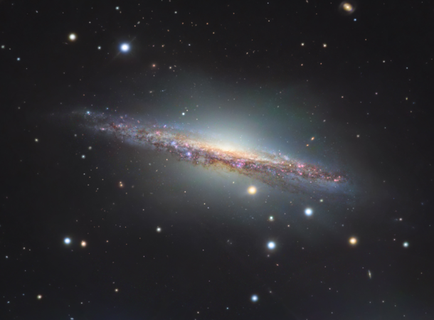 Edge on spiral galaxy NGC  roughly  million light-years away It is  larger than the Milky Way and has an unusually bright and active central bulge with massive amounts of warm carbon monoxide present evidence of intense star formation ESOs Very Large Tele