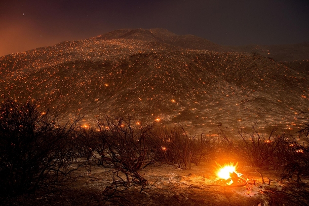 Embers from a wildfire smolder along Lytle Creek Road near Keenbrook California  by Noah Berger 