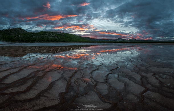 Fiery sunset reflected over the tendrils of the Grand Prismatic Spring Yellowstone 