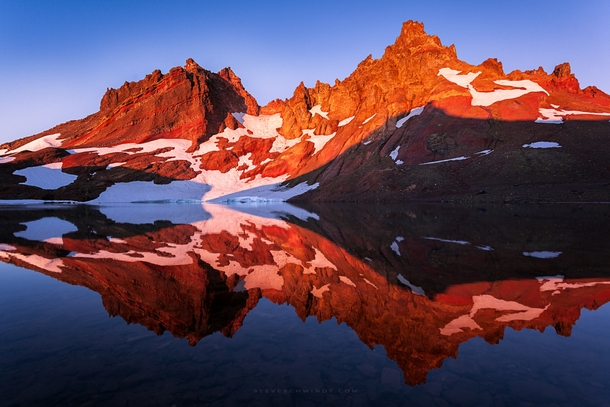 First light hitting Broken Top Mountain in central Oregon providing an incredible glow and reflection on its glacial lake 