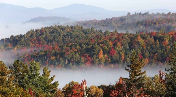 Fog sits in the valley of the White Mountains as leaves change colors Milan Hill NH  Photo by Jim Cole