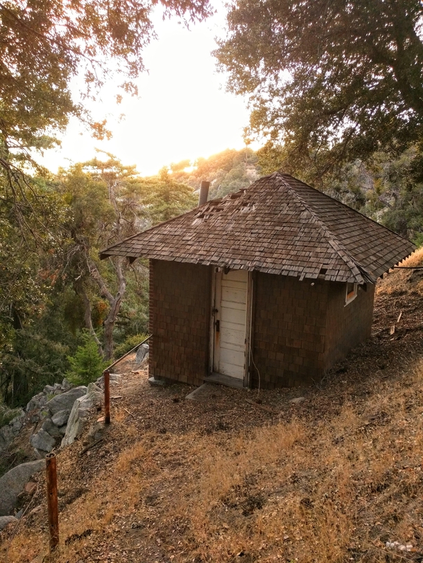 Forgotten cabin hidden just below the line of sight on the side of a hill