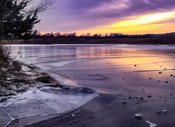 Frozen pond on an American prairie at sunset 