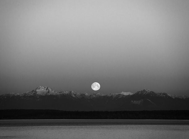 Full moon setting over the Olympic Mountains blackwhite seen from Seattle 