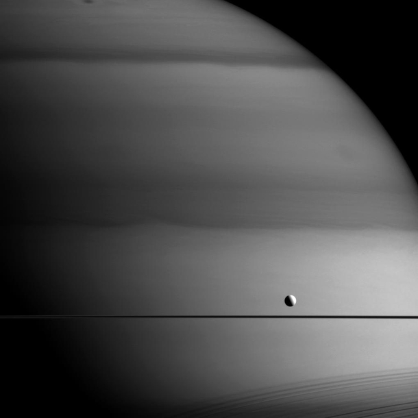 Gas giants are called giants for a reason This photo shows just a sliver of Saturn and its size compared to the tiny moon Dione This image shows how thin Saturns rings are when seen edge-on If you peek toward the bottom you will see a shadow cast by the r