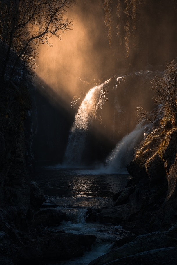 Golden light on a fairytale-like waterfall in Viken Norway  By Chrishoiberg