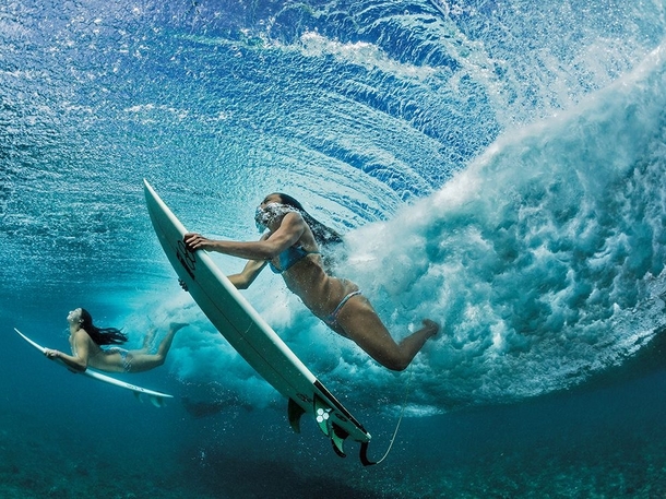 Haa Keaulana and Maili Makana dive under a wave on their way to surf near Makaha on Oahu Hawaii 