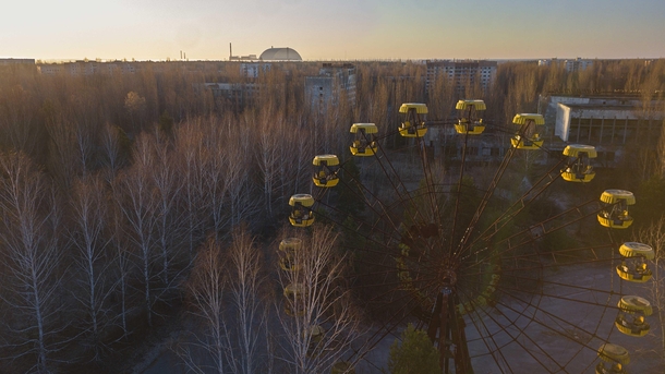 I flew my drone over the abandoned city of Pripyat Thats the Chernobyl reactor in the background with the amusement park ferris wheel in the foreground 