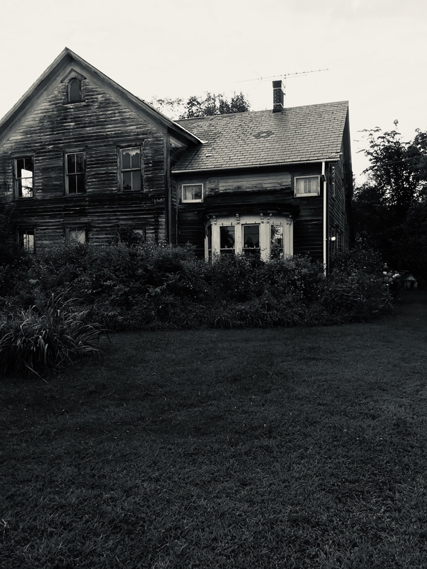 Inspired by another redditor My Great Grandparents dairy farm untouched in a decade since my Gram passed at  If you look close you can still see her knick knacks in the window and front porch lamp lit- Upstate NY