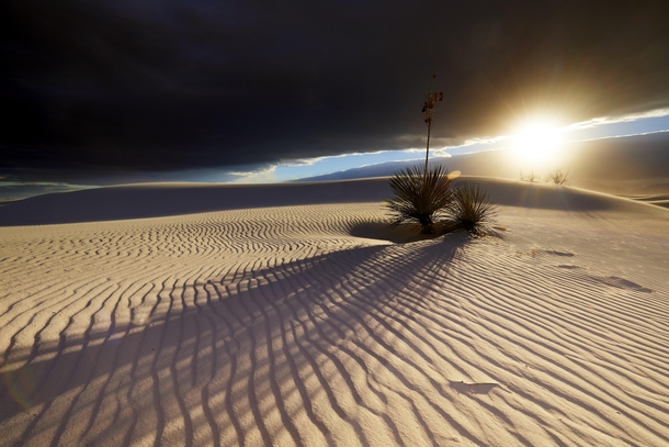 Late day sun peaking between the clouds in White Sands NM 