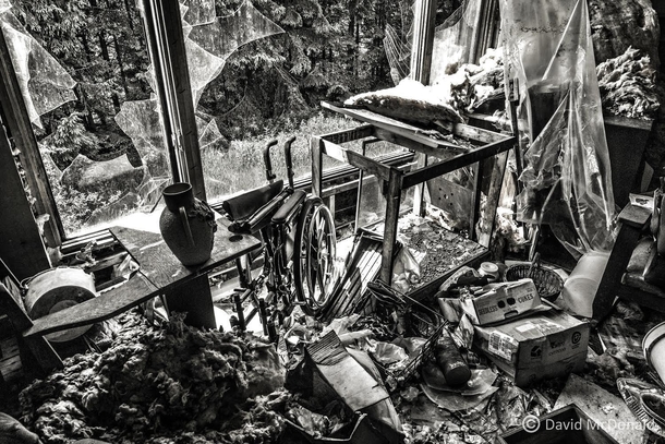 Living room with smashed window in an abandoned home in Ontario