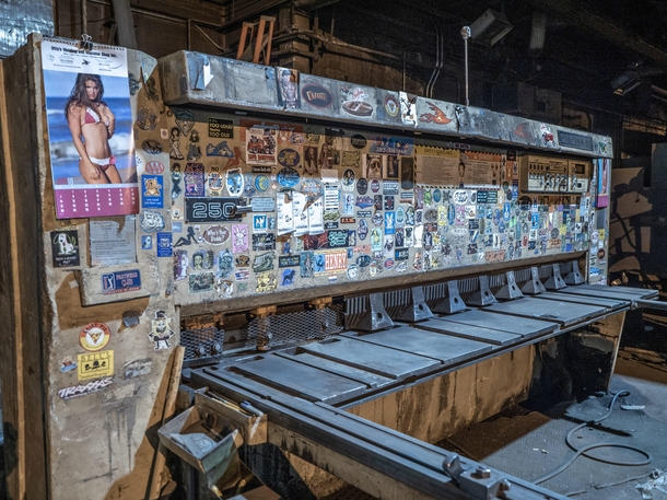 Lots of stickers on a machine in an abandoned manufacturing plant