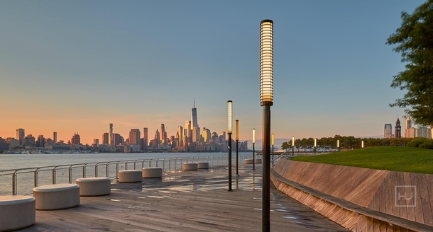 Lower Manhattan skyline from Hobokens Pier C Park during golden hour 